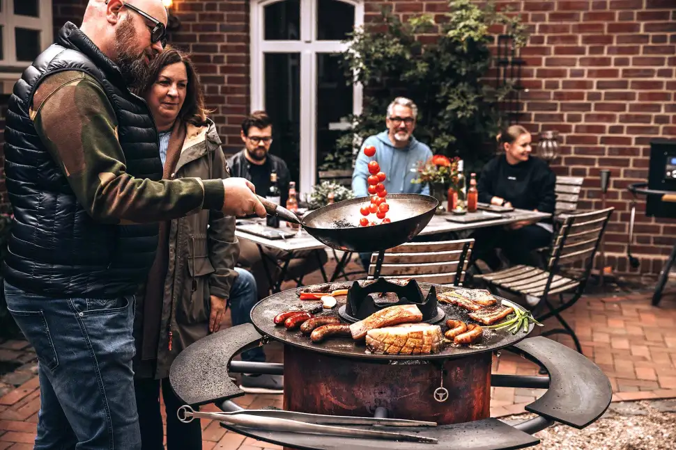 MOESTA BBQ bietet für seinen BANDIT FirePlace auch verschiedenes Zubehör an – z. B. ein praktisches Wok-Set, bestehend aus Wok-Krone, Wok und Wok-Löffel für die BBQ Disk. Foto: epr / MOESTA BBQ